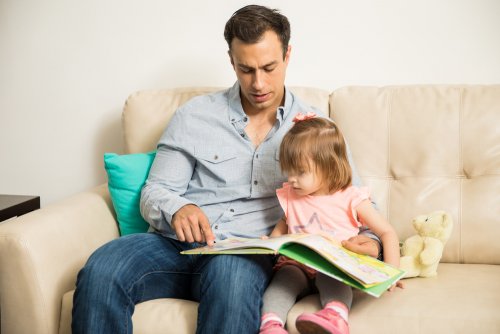 Padre leyendo a su hija y formando una familia monoparental.