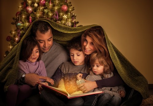 Padres con sus hijos leyendo cuentos sobre la Navidad para niños.