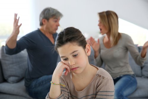 Padres discutiendo frente a su hija por su falta de comunicación.