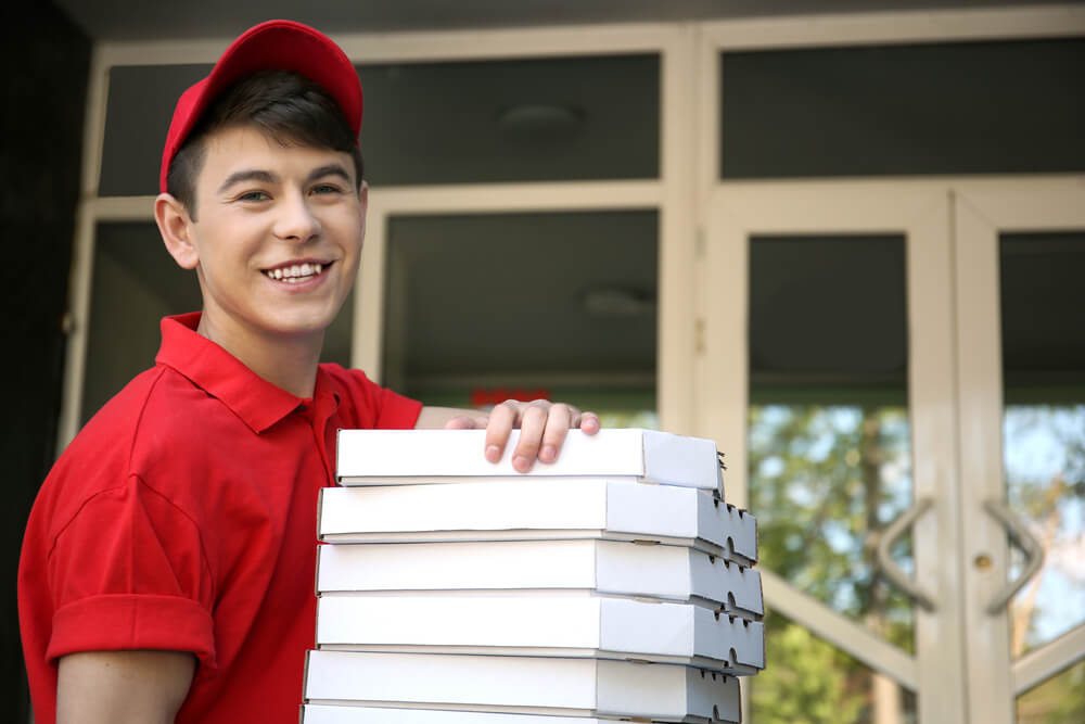 Chico adolescente de 16 años trabajando como repartidor de pizzas.