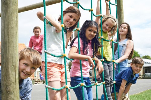 Niños en el recreo escolar descansando.
