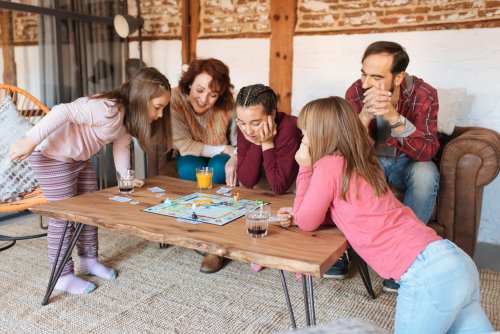 Familia jugando a juegos de mesar pero sin dejar ganar a sus hijos.