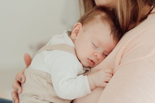 Mamá con su bebé en brazos durante su periodo correspondiente en la custodia compartida.