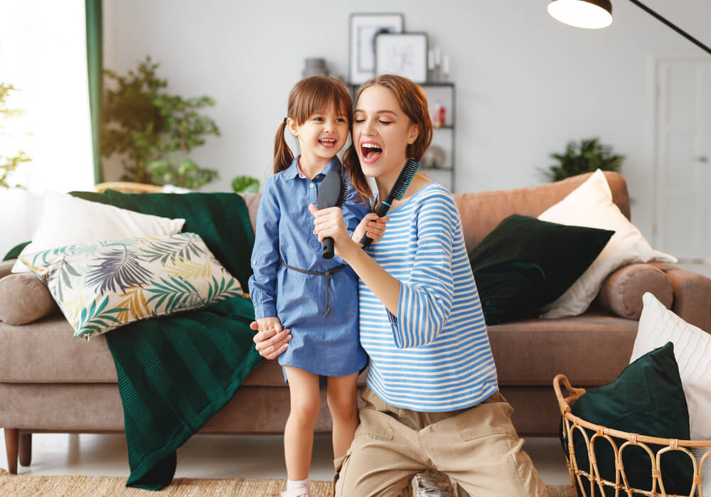Une maman et sa fille qui chantent dans le salon.