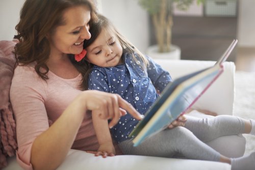 Madre leyendo un cuento educativo a su niña.