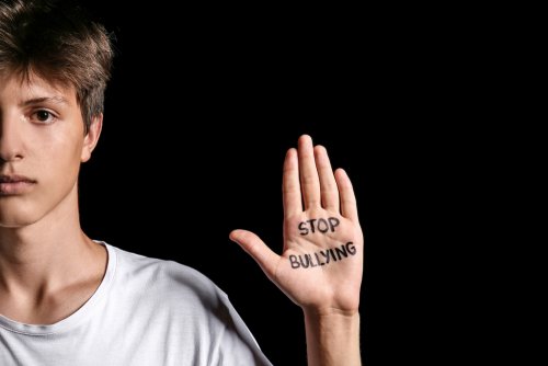 Niño con la frase "stop bullying" escrita en la mano.