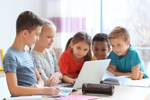 Niños trabajando en clase con el ordenador.