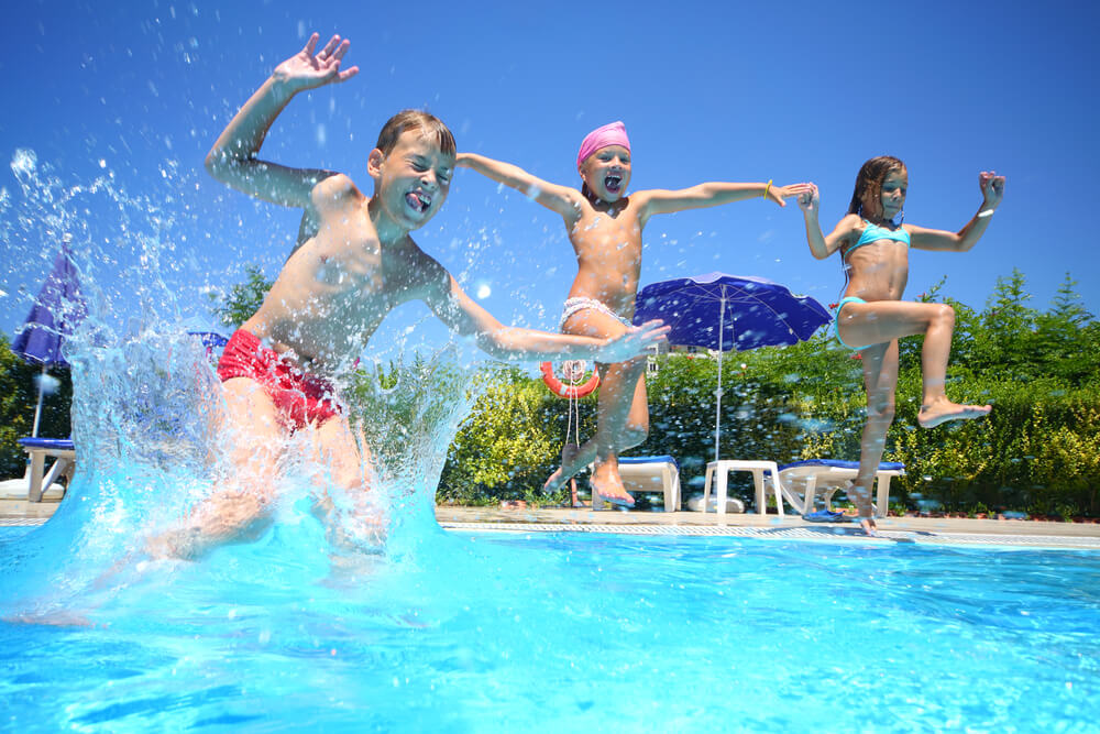 Barn som hoppar i en simbassäng.