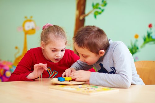 Niños con necesidades especiales jugando en el aula.