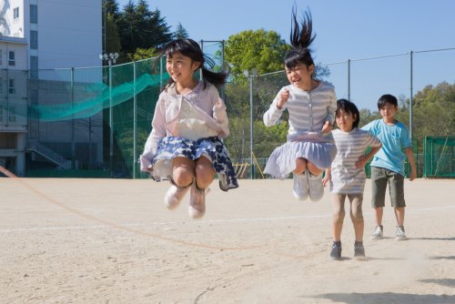 Niños saltando a la comba durante el recreo.