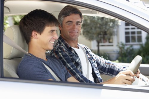 Padre enseña a conducir el coche a su hijo.