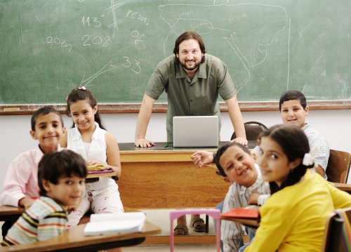 Profesor en clase con sus alumnos aplicando las inteligencias múltiples de Gardner en su educación.