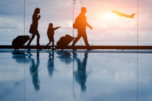 Familia en el aeropuerto buscando el vuelo con su hija.