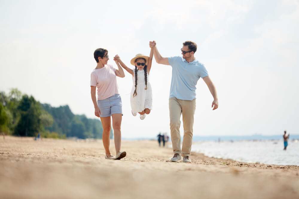 A family enjoying a walk down the beach.