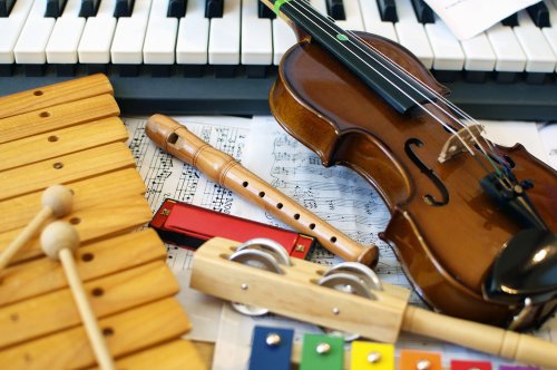 Varios instrumentos musicales, como un violín o un piano, encima de una mesa con partituras.