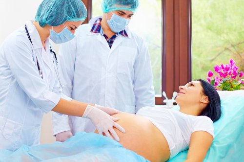 Mujer embarazada siendo examinada para hacerla una posible versión cefálica externa.