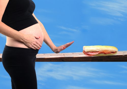 Mujer embarazada rechazando un bocadillo para evitar la listeriosis neonatal.