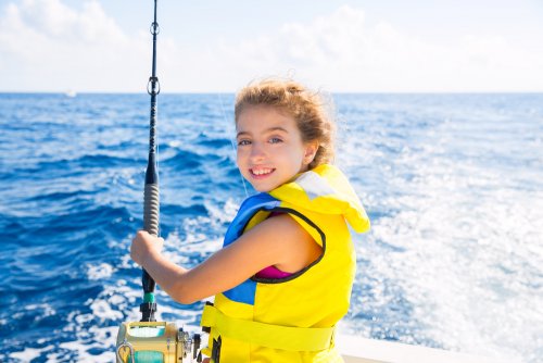 Niña navegando por el mar con el chaleco salvavidas.