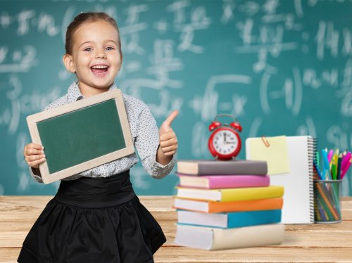 Niña con una gran inteligencia tras llenar la pizarra de fórmulas matemáticas.