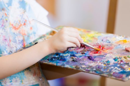 Niña pintando un cuadro trabajando las inteligencias múltiples en el aula.