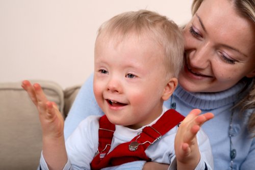 Niño con discapacidad recibiendo el afecto de su madre.