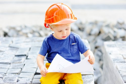 Niño constructor mirando unos planos.