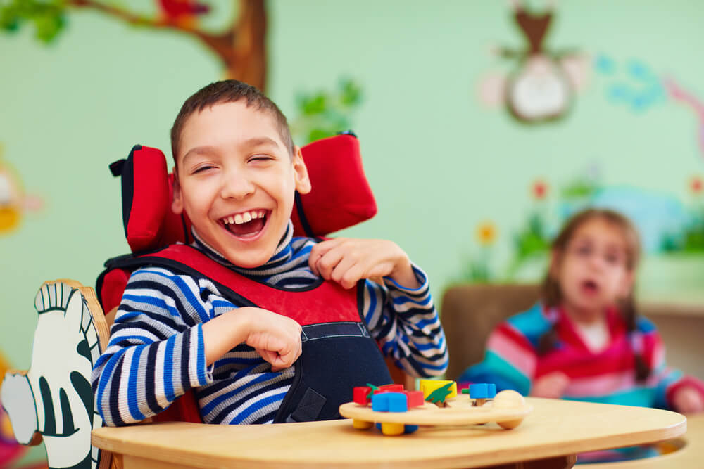 Niño con discapacidad motora en clase muy sonriente