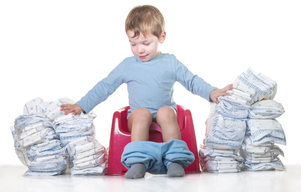 Un enfant sur le pot avec des couches de chaque côté.