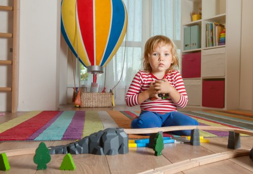 Niño agarrando sus juguetes de forma egoísta.