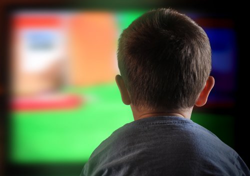 Niño mirando la televisión con anuncios publicitarios.