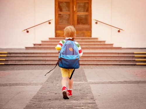 Niño yendo a clase en su nuevo colegio tras el cambio a uno nuevo de la Unión Europea.