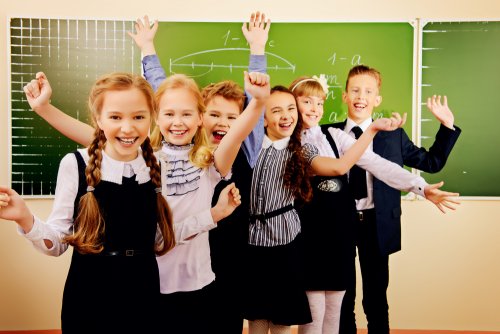 Niños en clase muy felices gracias a la nueva ley de educación para todos.