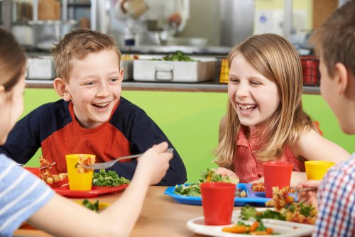 Niños disfrutando de una comida en el comedor escolar.