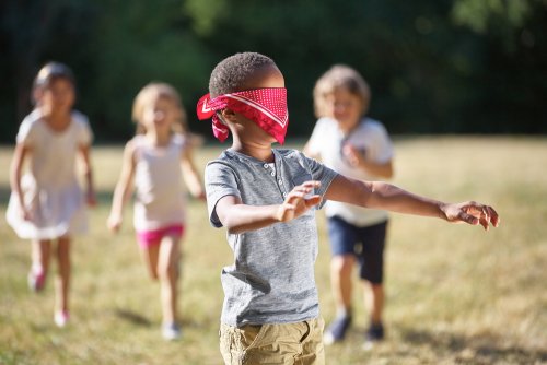 Niño con una venda en los ojos jugando para la estimulación táctil.