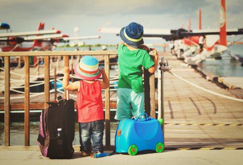 Niños mirando aviones antes de volver de su viaje al extranjero con sus padres.
