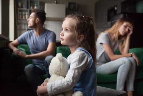 Padres que no se hablan pero que no se piden el divorcio por sus hijos. Su hija está en medio abrazando un peluche.