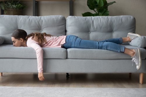 Adolescente tumbada en el sofá sin motivación porque no quiere estudiar.