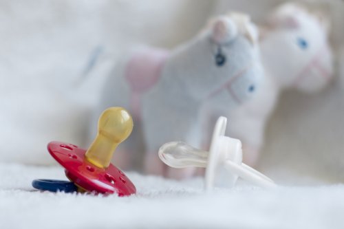 Des tétines et un doudou derrière.