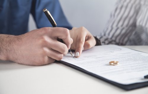 Pareja firmando el régimen matrimonial en que estarán casados.
