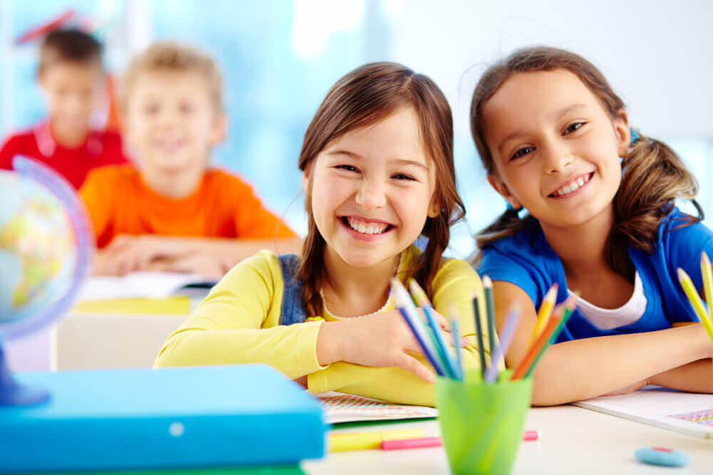 Deux jeunes filles heureuses en classe.
