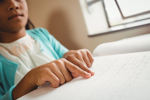 Niña aprendiendo a leer en braille debido a su discapacidad visual.