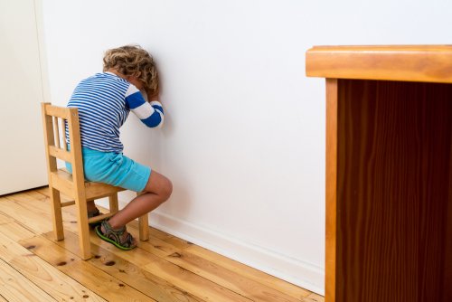 Niño castigado cara a la pared.