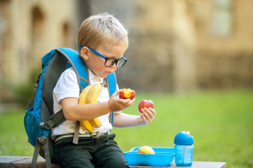 Niño comiendo frutas como parte de sus meriendas saludables para el recreo.