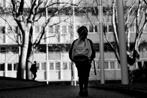 Niño solitario andando por la calle a la salida del colegio tras sufrir violencia escolar.