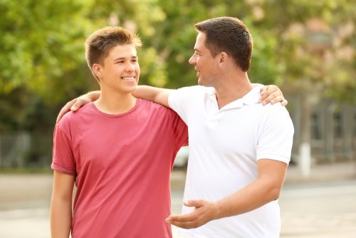 Père parle tranquillement avec son fils adolescent.