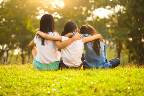 Amigas dándose un abrazo en el parque.