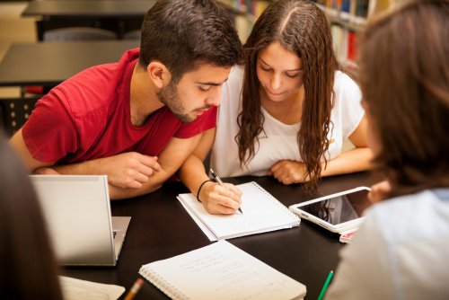 Adolescentes estudiando un examen en grupo.