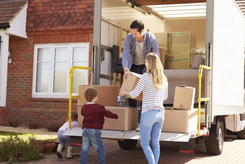 Familia descargando del camión las cajas de las mudanzas, que son difíciles en la infancia.