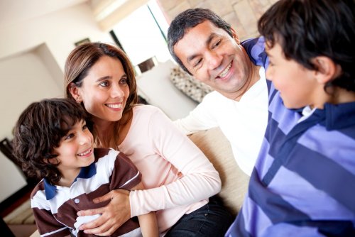 Padres hablando con sus hijos y diciéndoles algunas frases que promueven comportamientos positivos.
