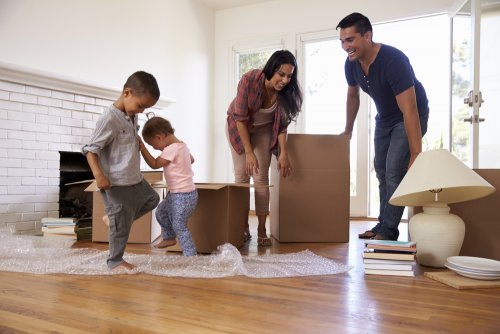 Familia en el salón de su nueva caja con las cajas de la mudanza.